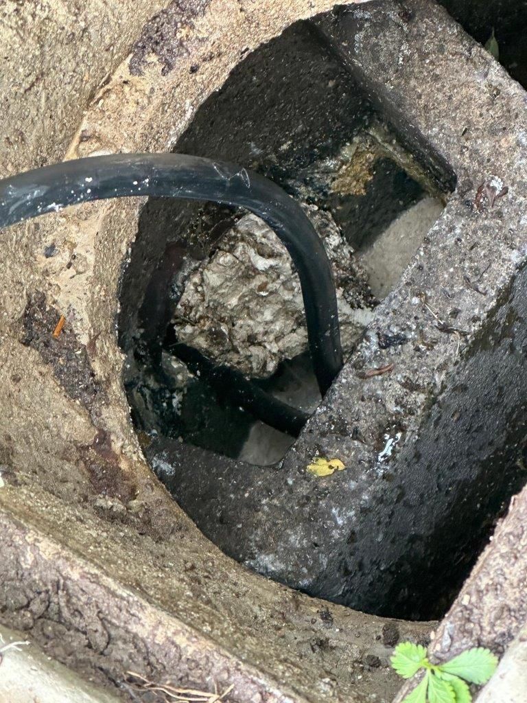 Primo piano di uno scarico da cui esce un tubo.