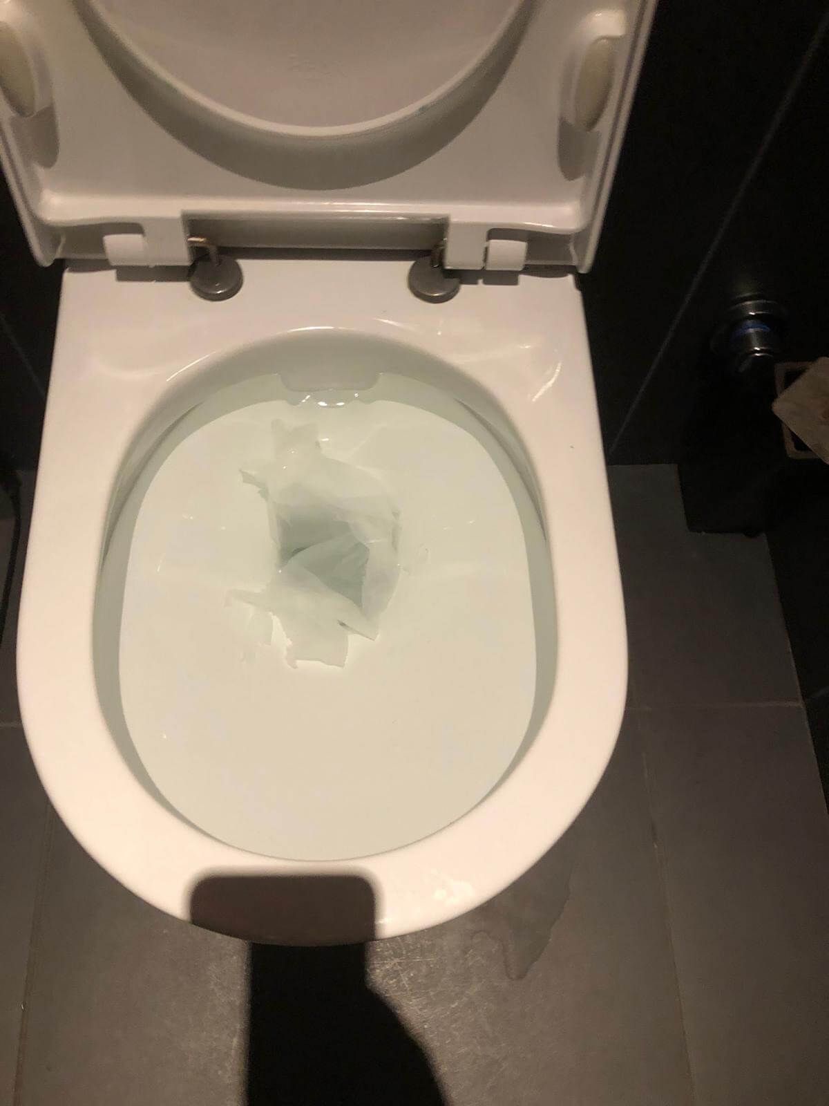 Primo piano di uno scarico da cui esce un tubo.