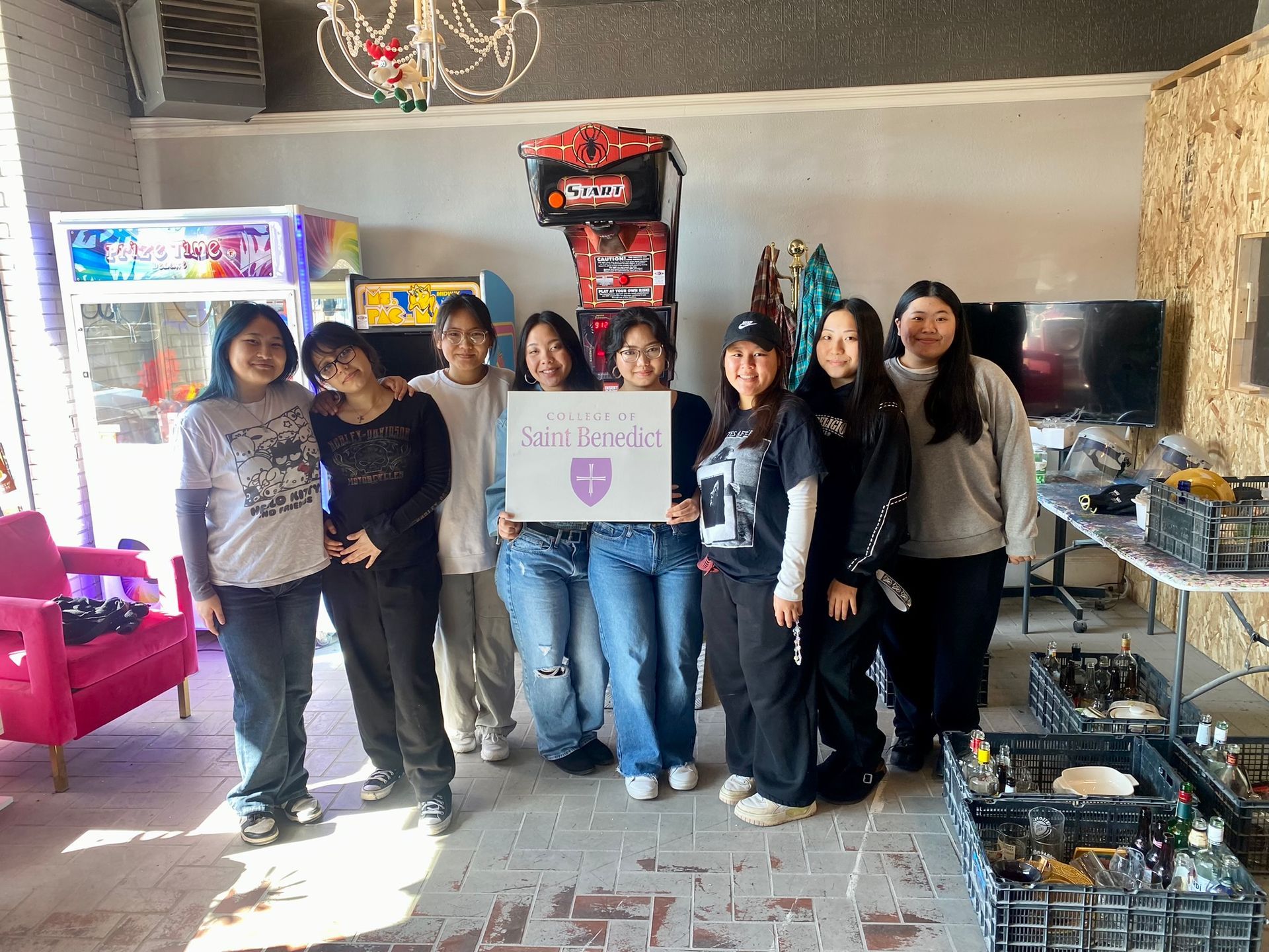 A group of young women are posing for a picture in a room.