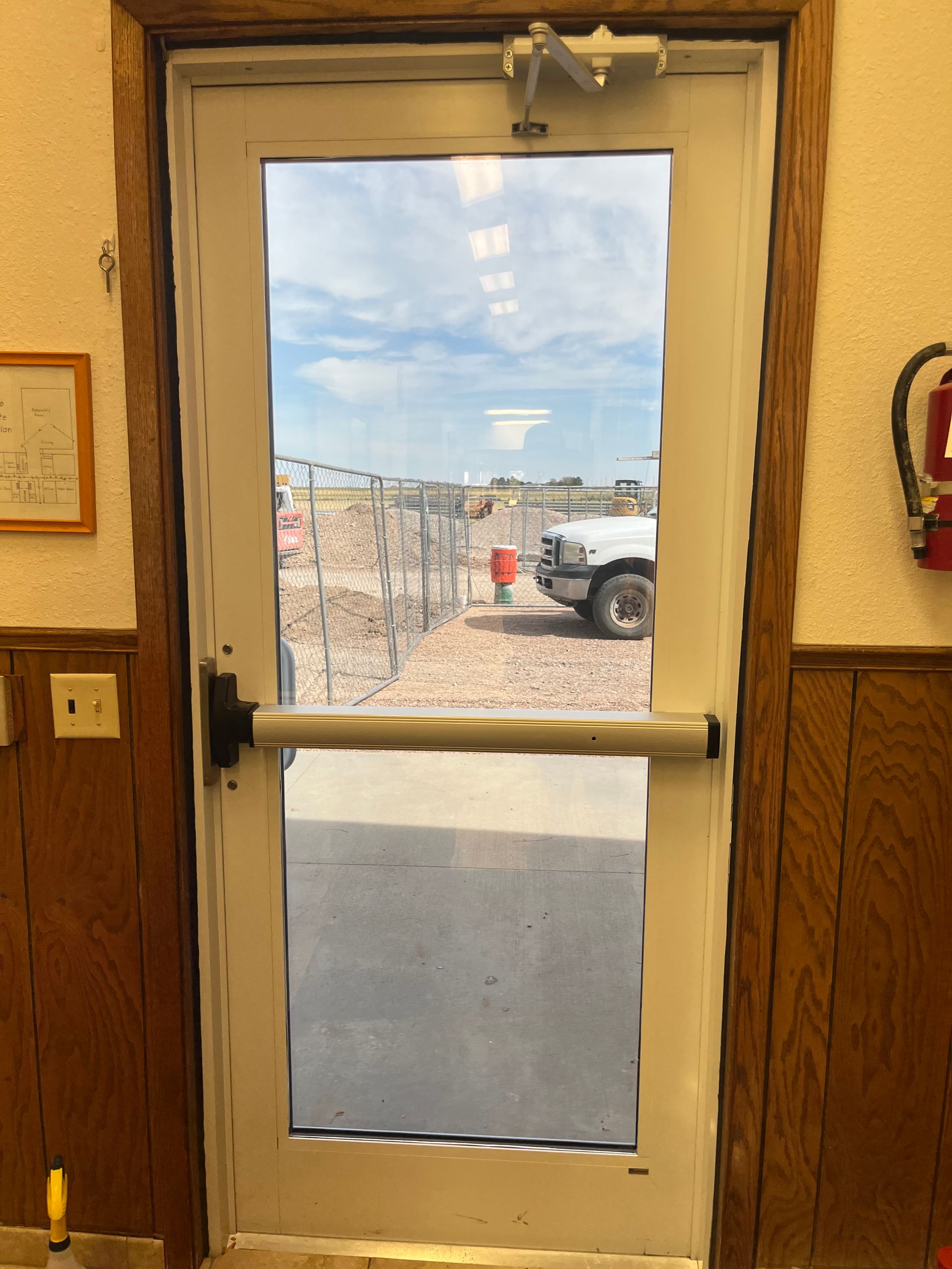 A white door with a fire extinguisher next to it