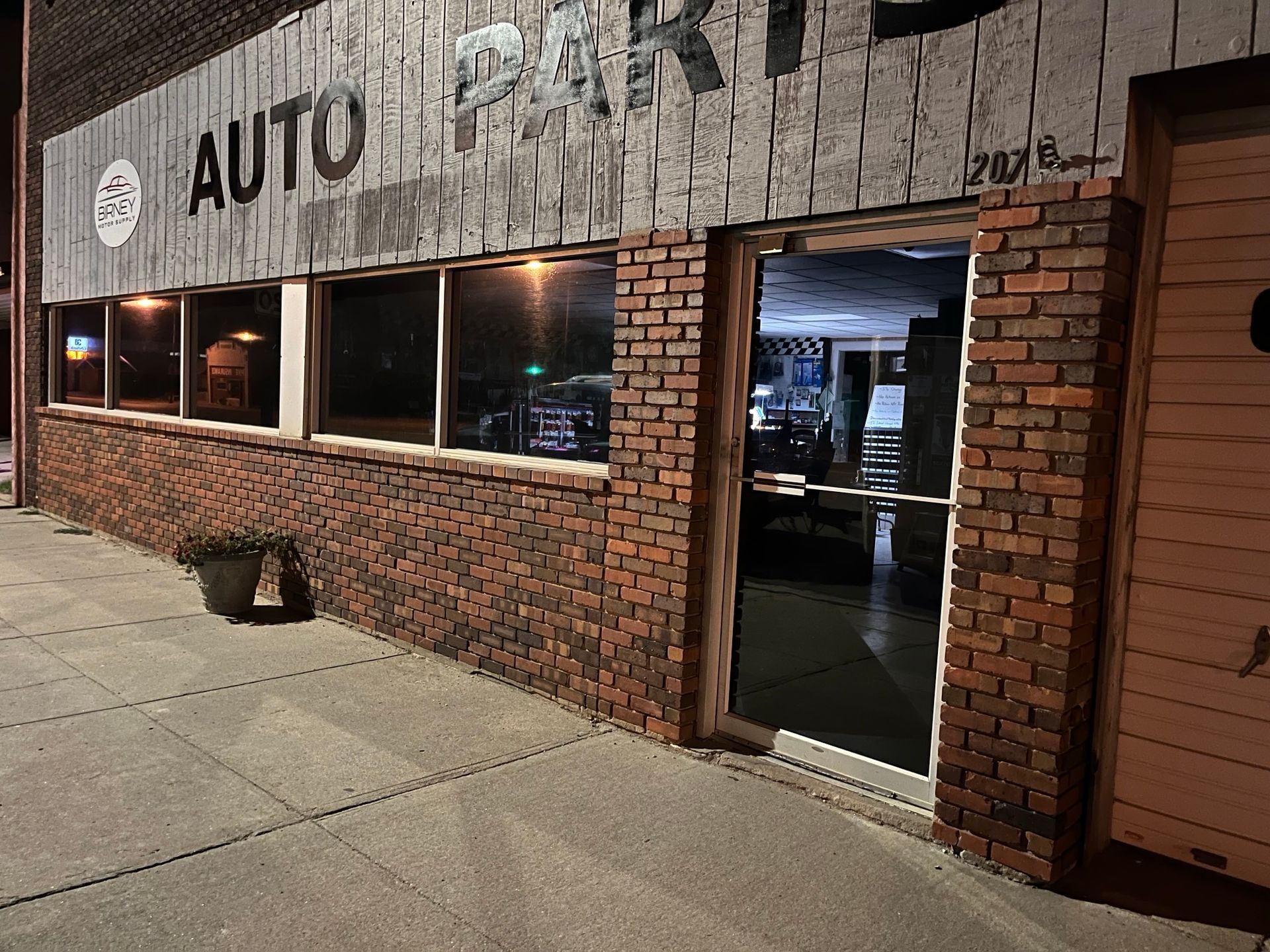 A brick building with a sign that says auto parts on it.