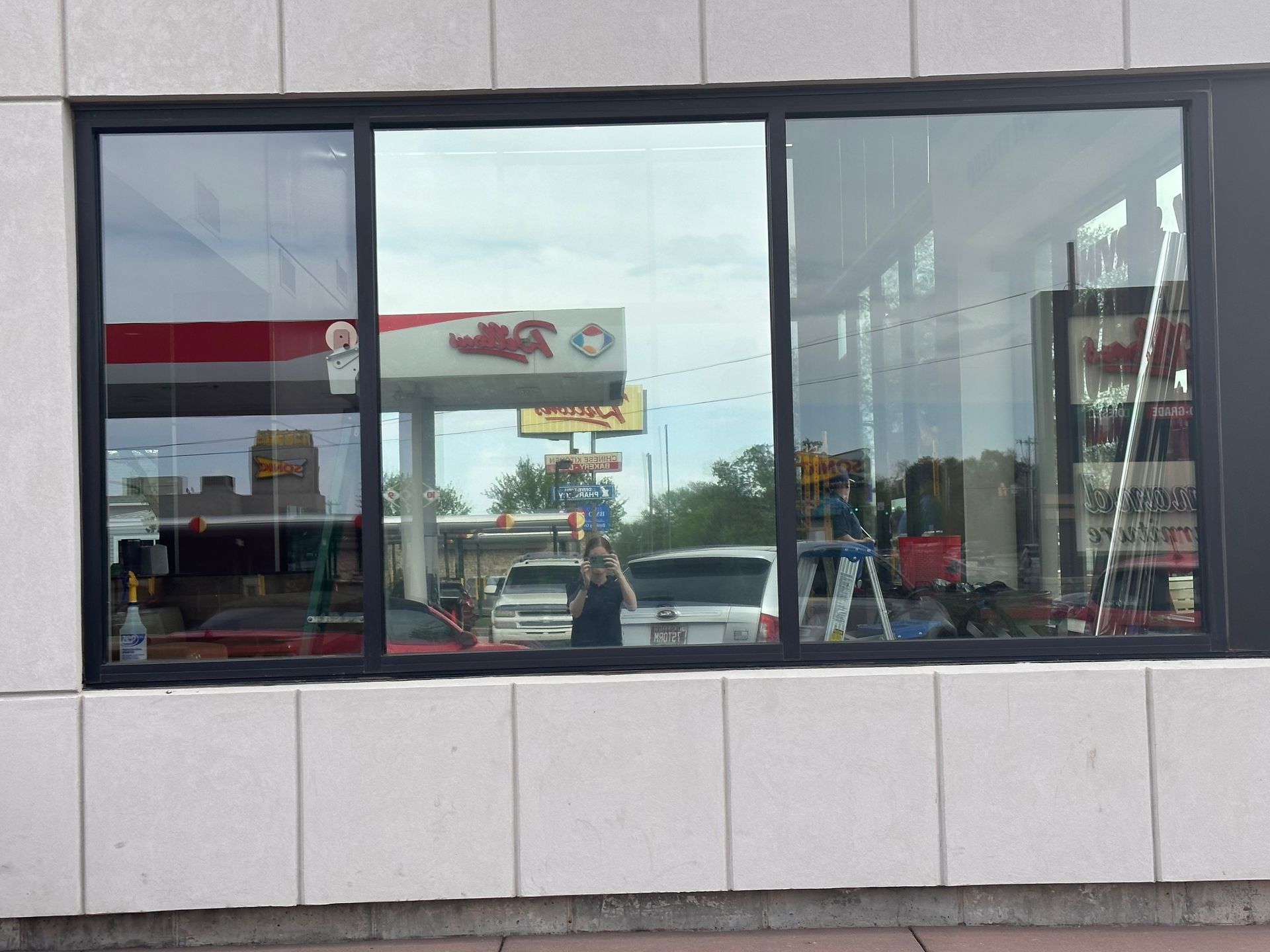 A window with a reflection of a gas station in it