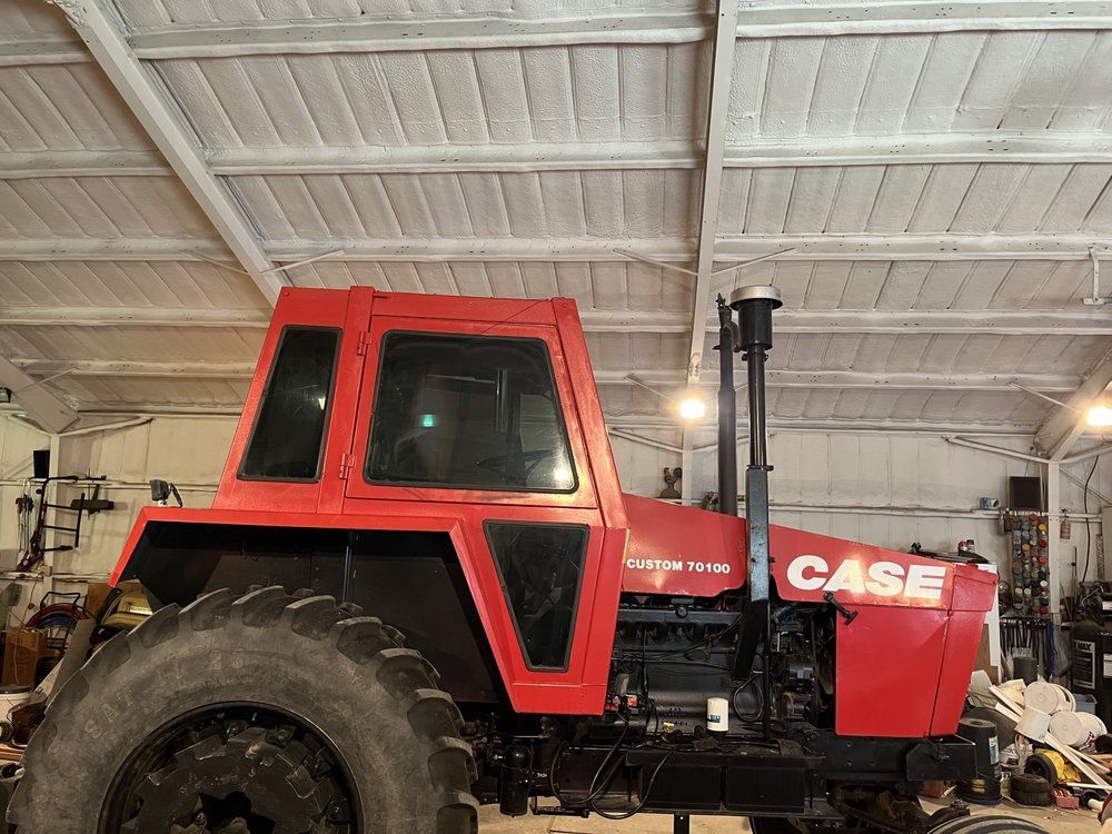 A red case tractor is parked in a warehouse.