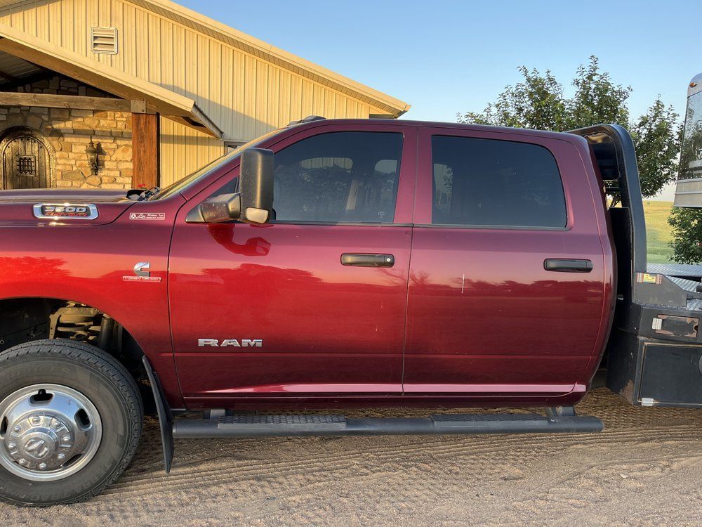 A red ram truck is parked in front of a house.
