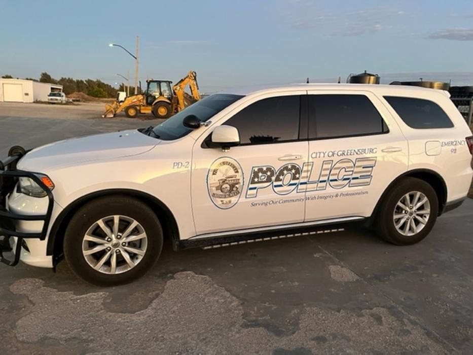 A white police car is parked in a parking lot