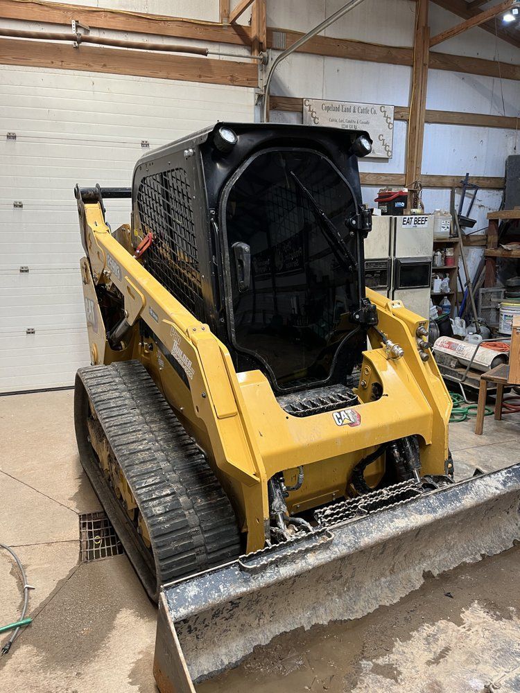 A bulldozer is parked in a garage next to a garage door.