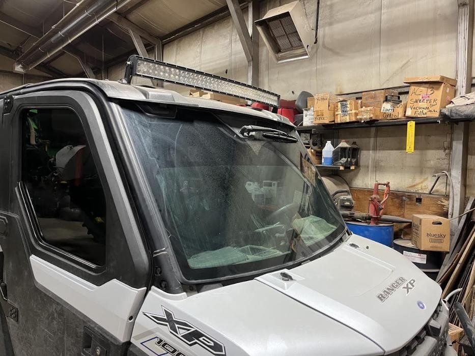 A white and black utility vehicle is parked in a garage.