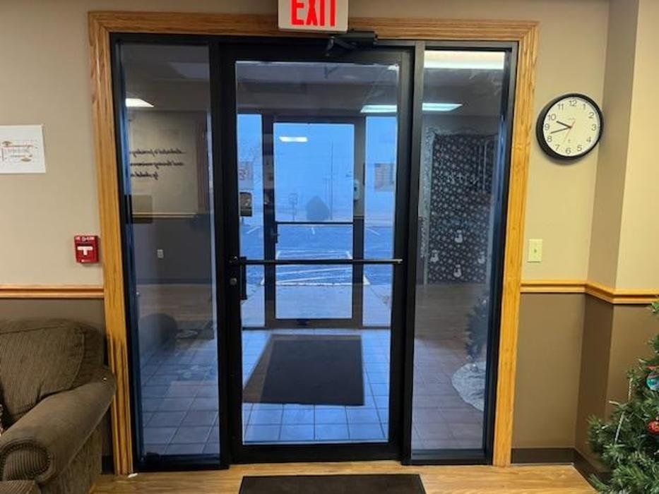 A glass door with a red exit sign above it