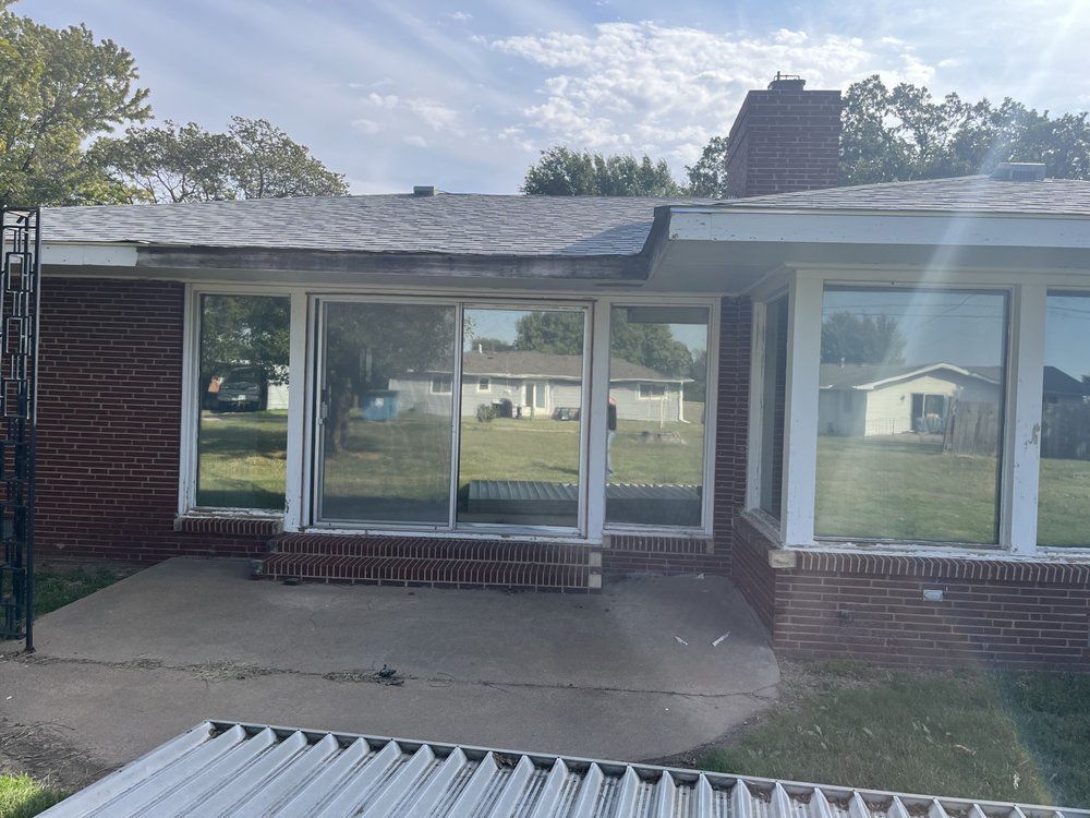 A brick house with sliding glass doors and a roof.