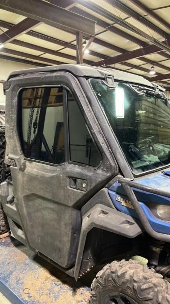 A dirty atv is parked in a garage.