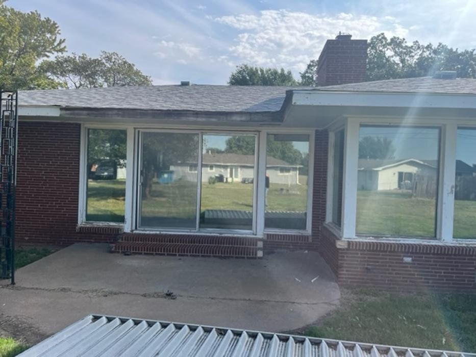 A brick house with sliding glass doors and a roof.