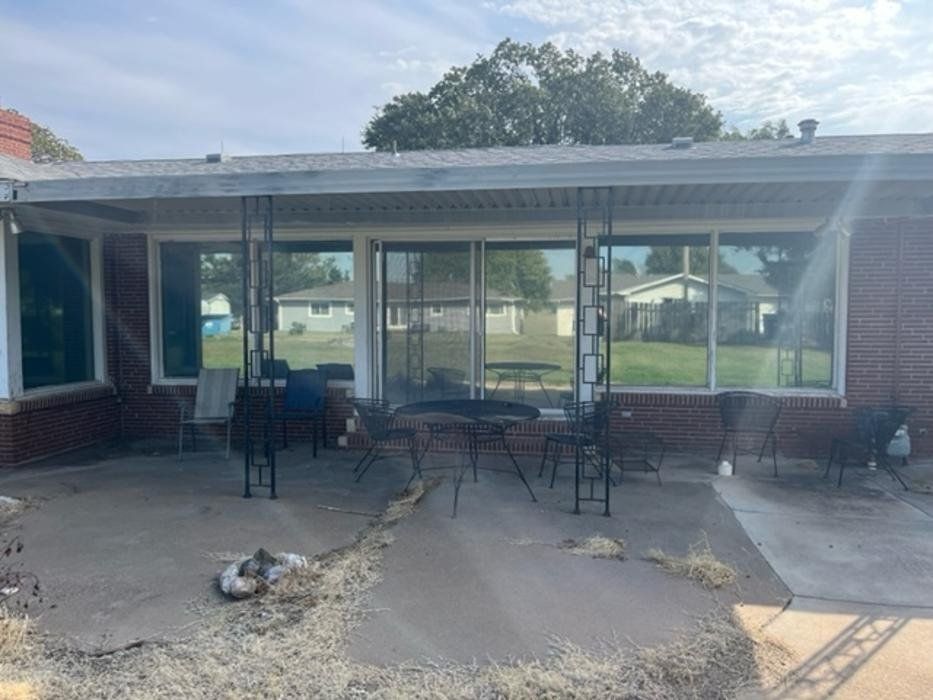 A brick house with a patio and a table and chairs in front of it.