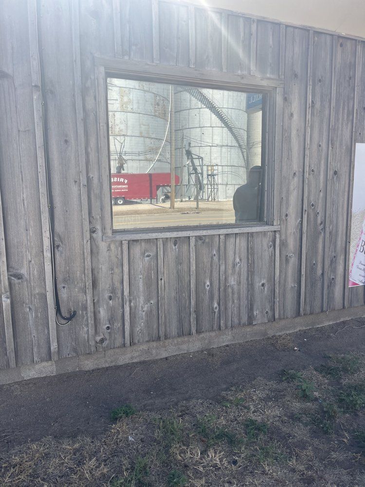 A wooden building with a large window on the side of it.