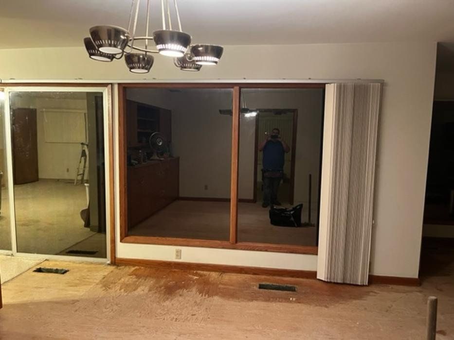 A living room with a sliding glass door and a chandelier.