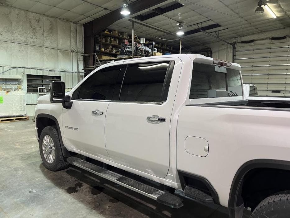 A white pickup truck is parked in a garage.
