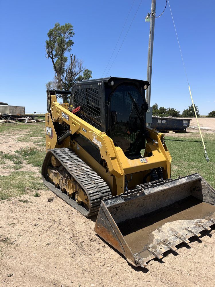 A yellow bulldozer is parked in a dirt field.