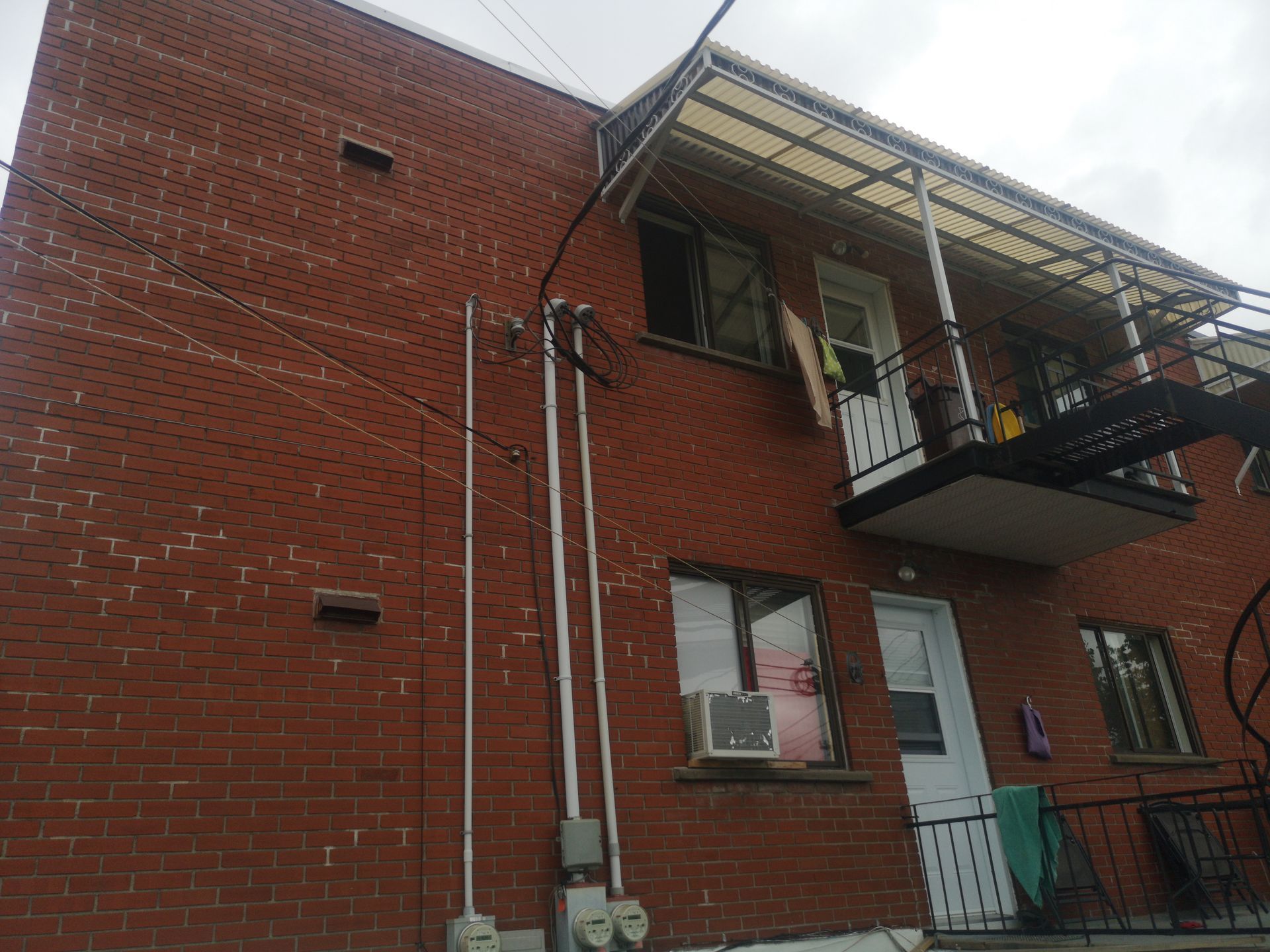 Un bâtiment en brique avec un balcon et une issue de secours