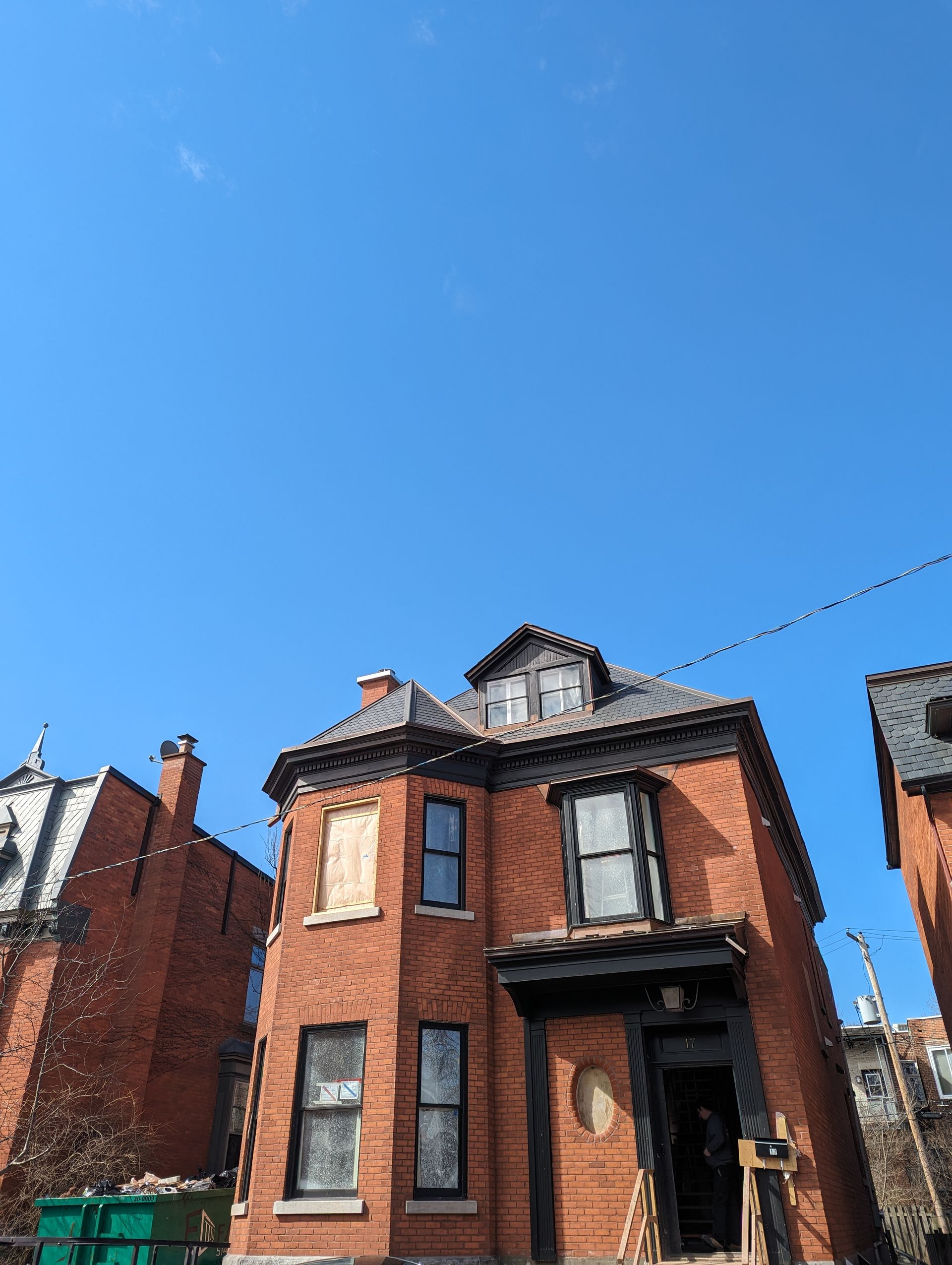 Une maison en brique avec un ciel bleu en arrière-plan