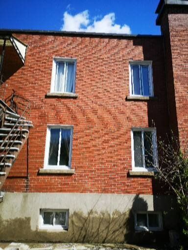 Un bâtiment en brique rouge avec des fenêtres et des escaliers blancs
