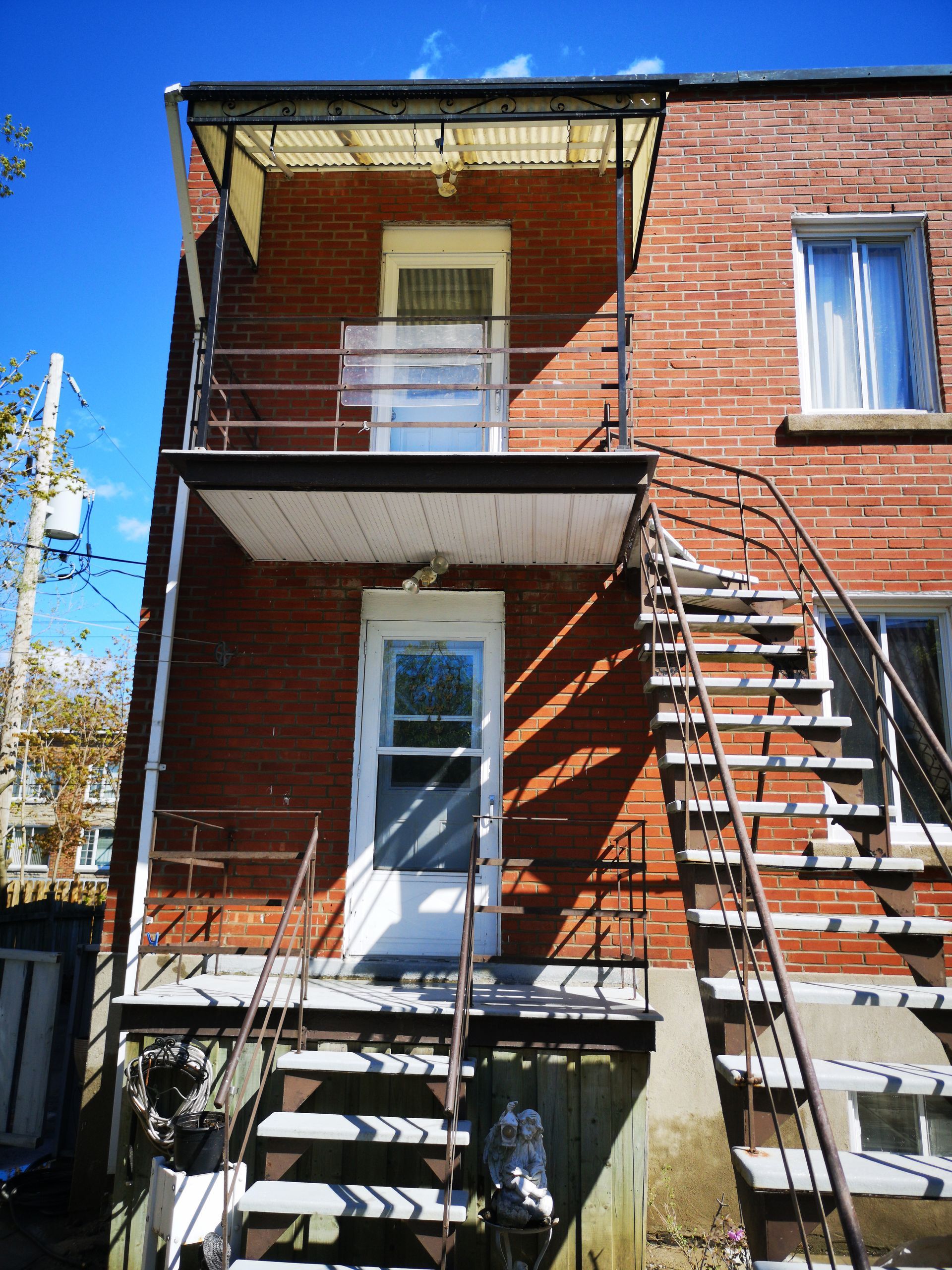 Un immeuble en brique avec des escaliers menant au deuxième étage