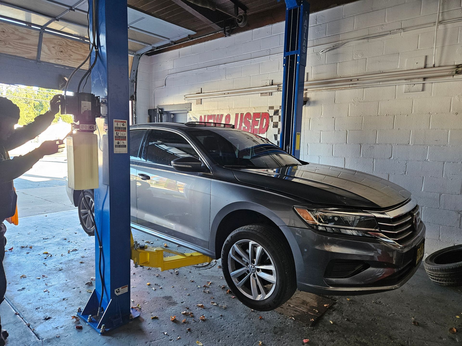 A car is sitting on a lift in a garage.