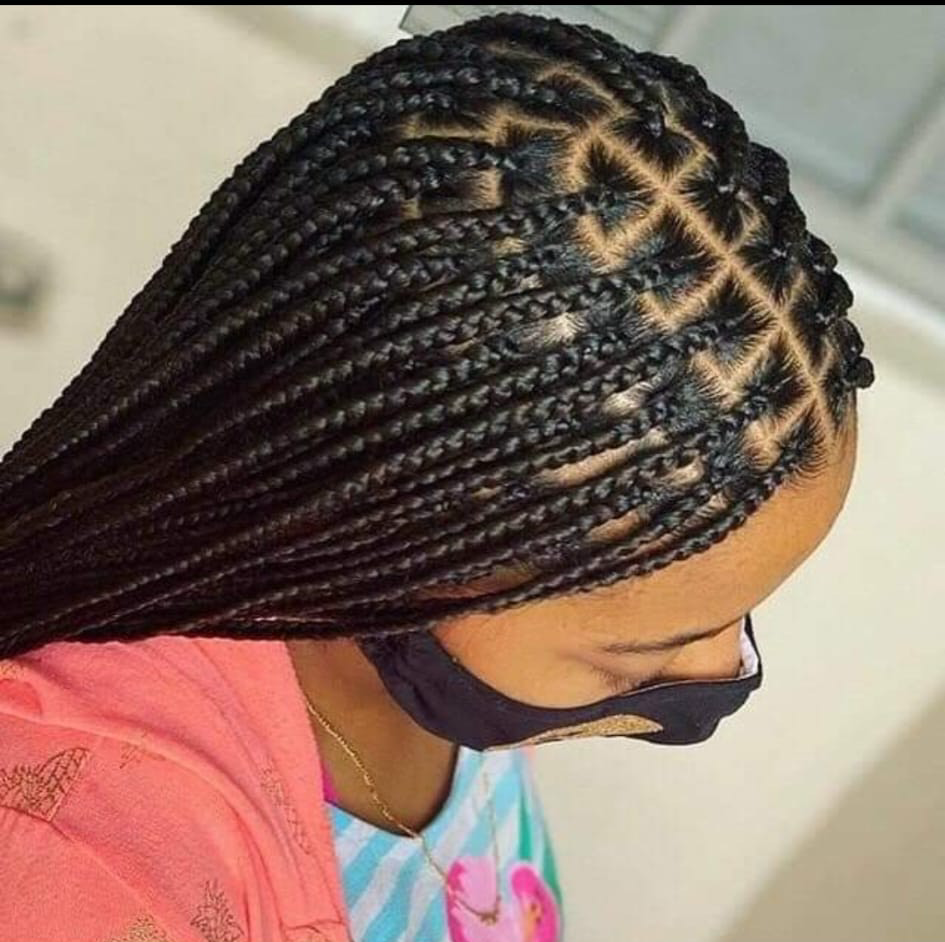 A person is holding a bunch of braids in their hand.