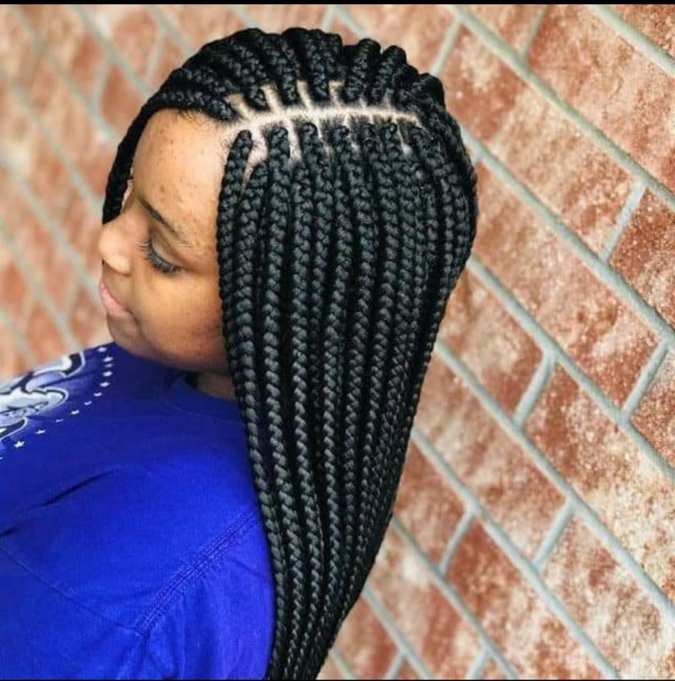 A woman wearing glasses and braids in her hair