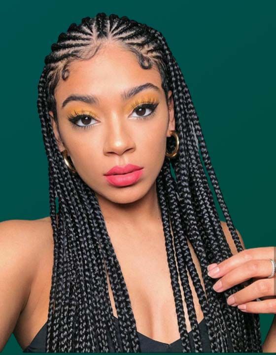 A woman with braids is wearing a black tank top