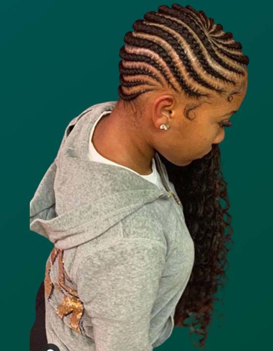 A little girl with braids in her hair is wearing a gray hoodie.