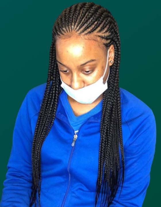 A woman with braids wearing a blue jacket and a face mask