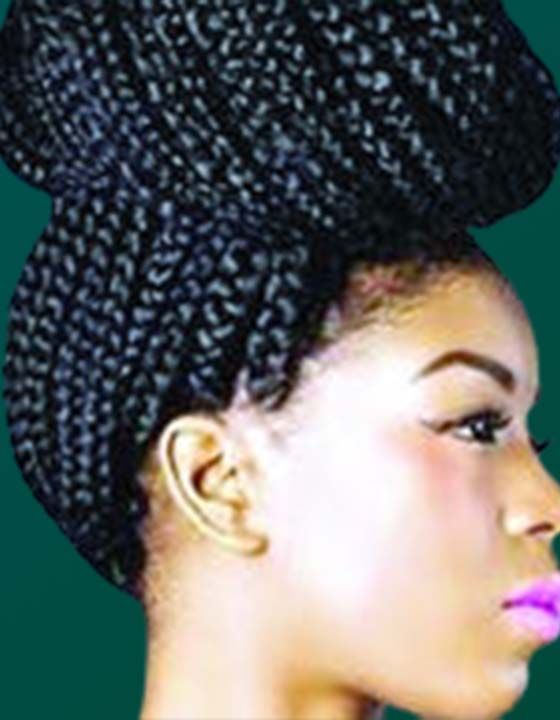 A woman with braids in her hair is wearing a turban.