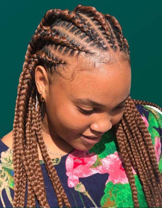 A woman with braids is wearing a floral shirt