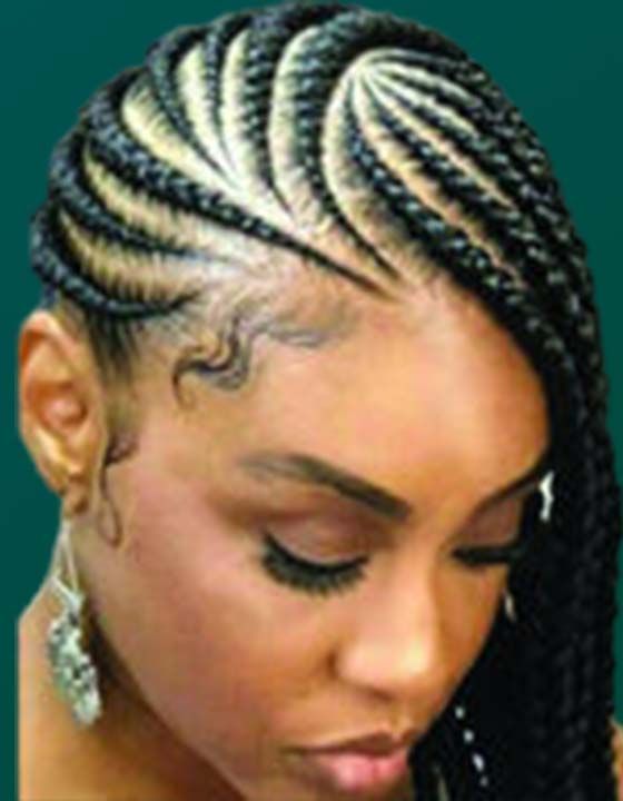 A close up of a woman 's face with braids in her hair.
