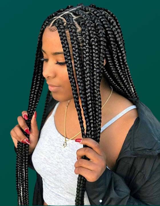 A woman with braids is wearing a white tank top and a black jacket