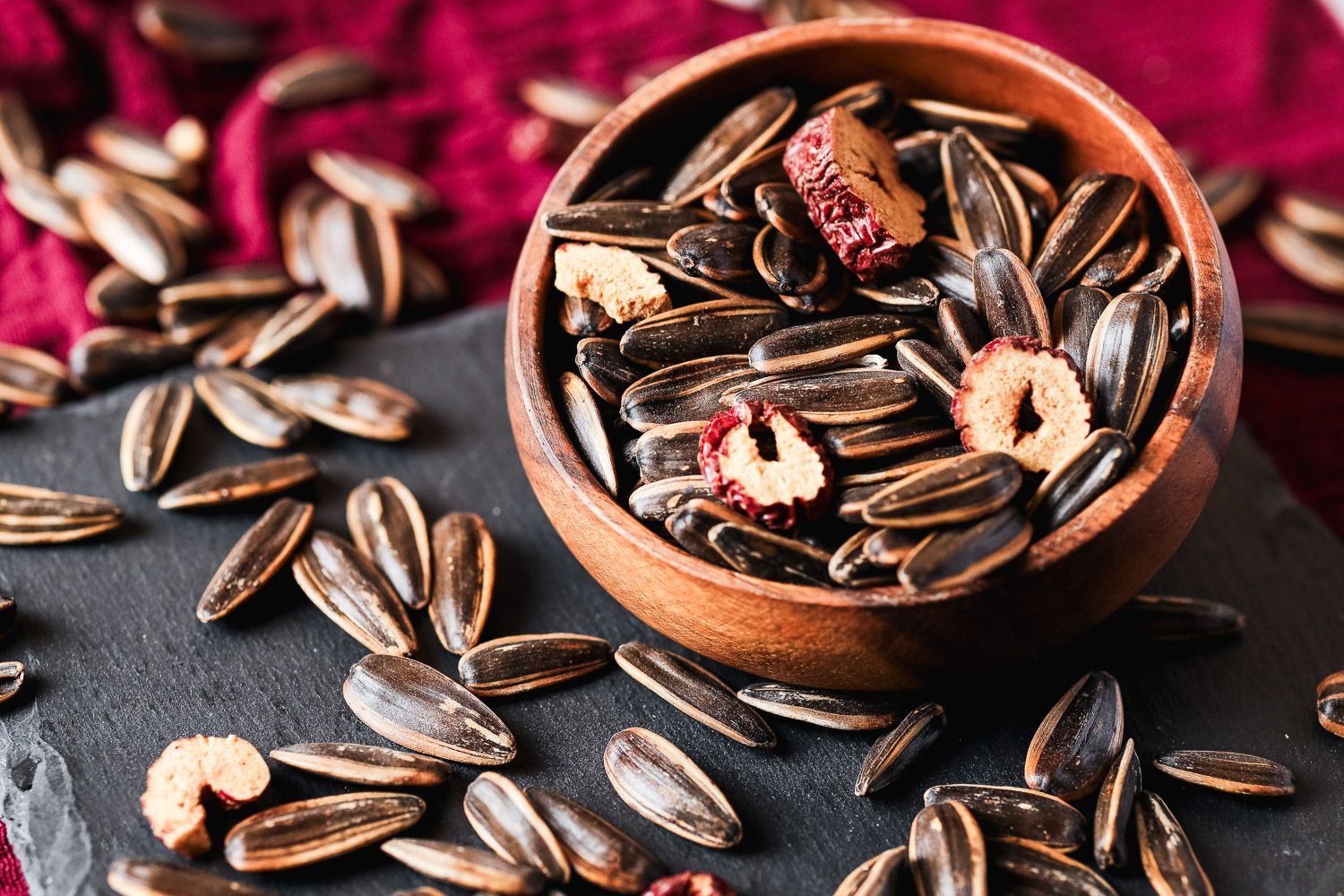 Two red gift boxes with gold floral patterns and a ribbon handle, set against a matching deep red background.