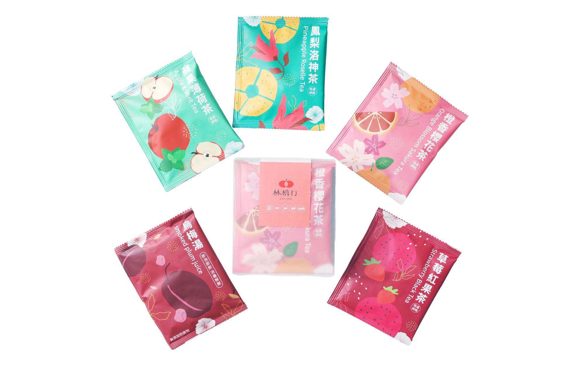 Six small, colorful, square sachets featuring various fruit and floral designs arranged around a central pink package.