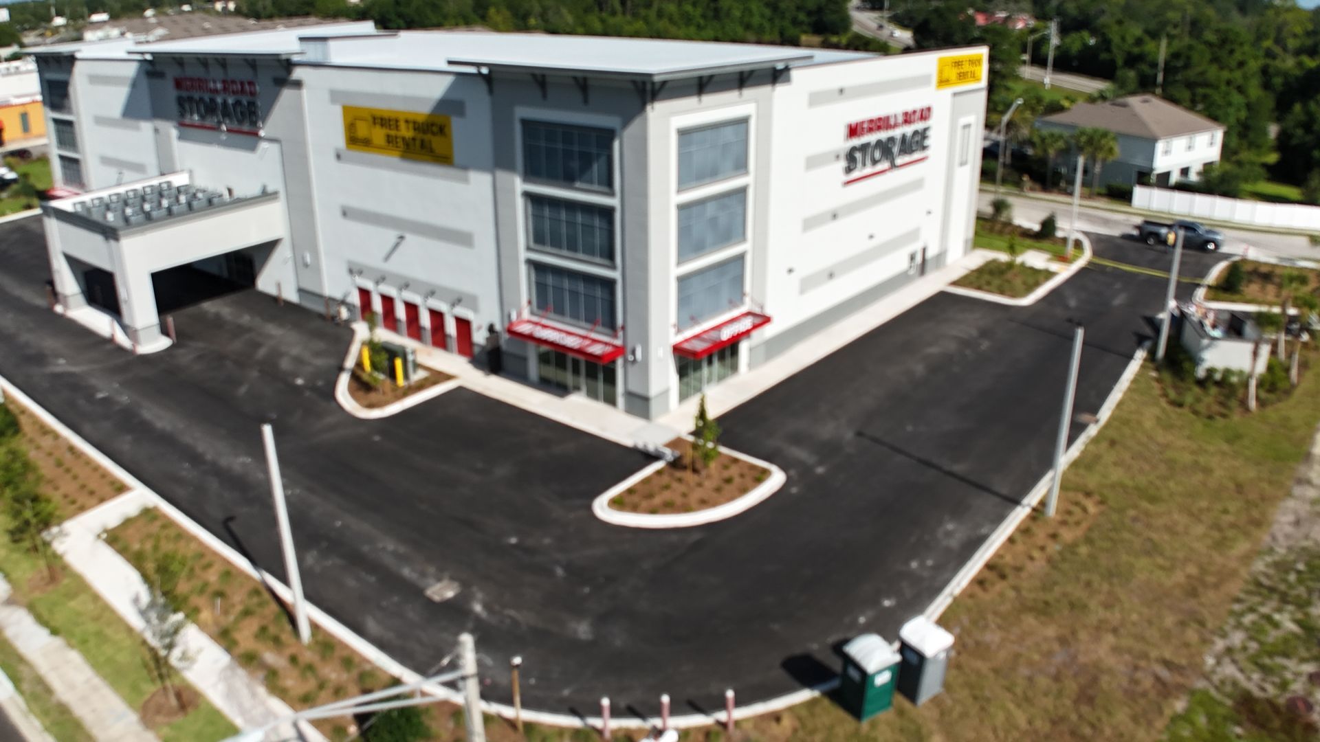 An aerial view of a large building with a parking lot in front of it.