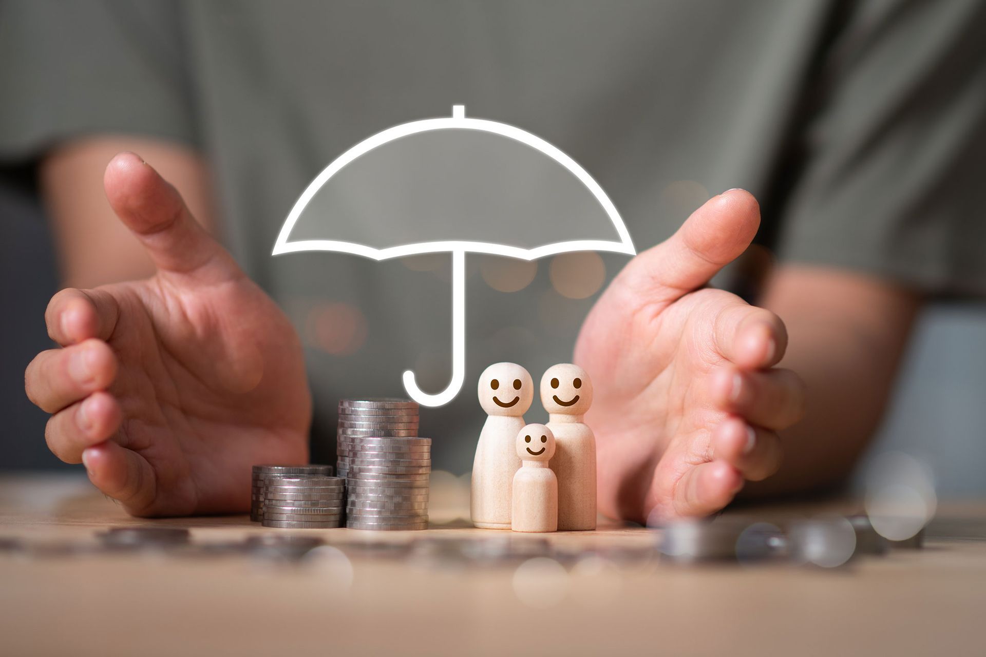 Hands cupping a family of wooden figures under an umbrella graphic, next to stacks of coins.