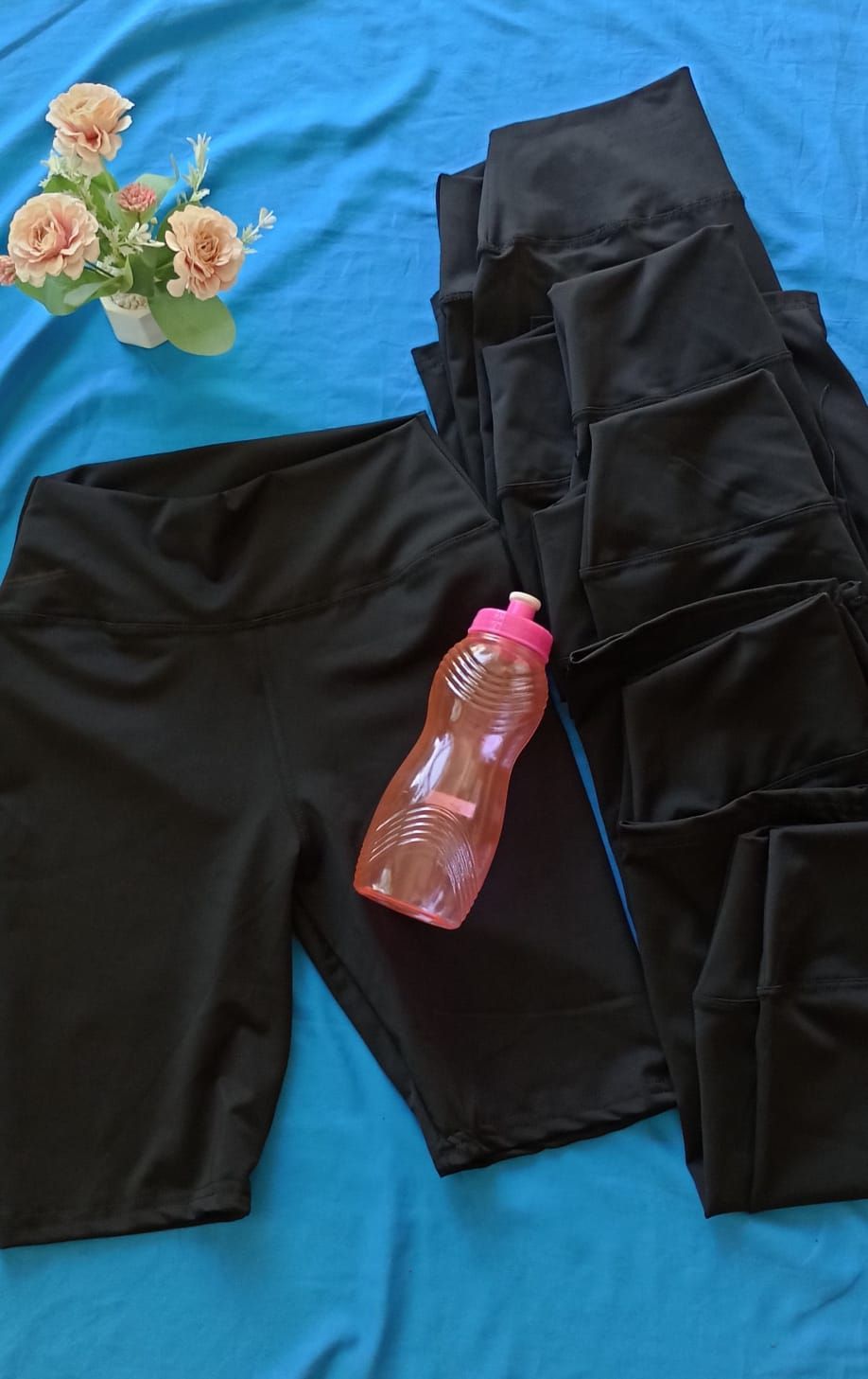 Pantalones cortos de ciclista negros de talle alto, exhibidos sobre un fondo azul brillante.