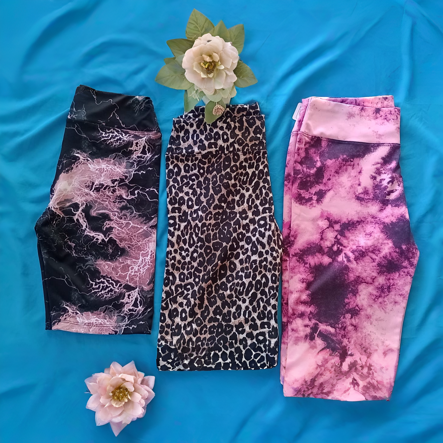 Pantalones cortos de ciclista con un estampado tie-dye en rosa y morado oscuro, mostrados extendidos.