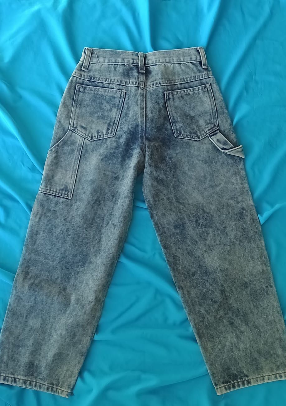 Un par de pantalones vaqueros de mezclilla con efecto desteñido y etiqueta de la marca.