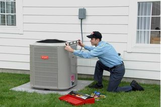 RMG Air Conditiioning and Heating Services working on an air conditioner outside a homne