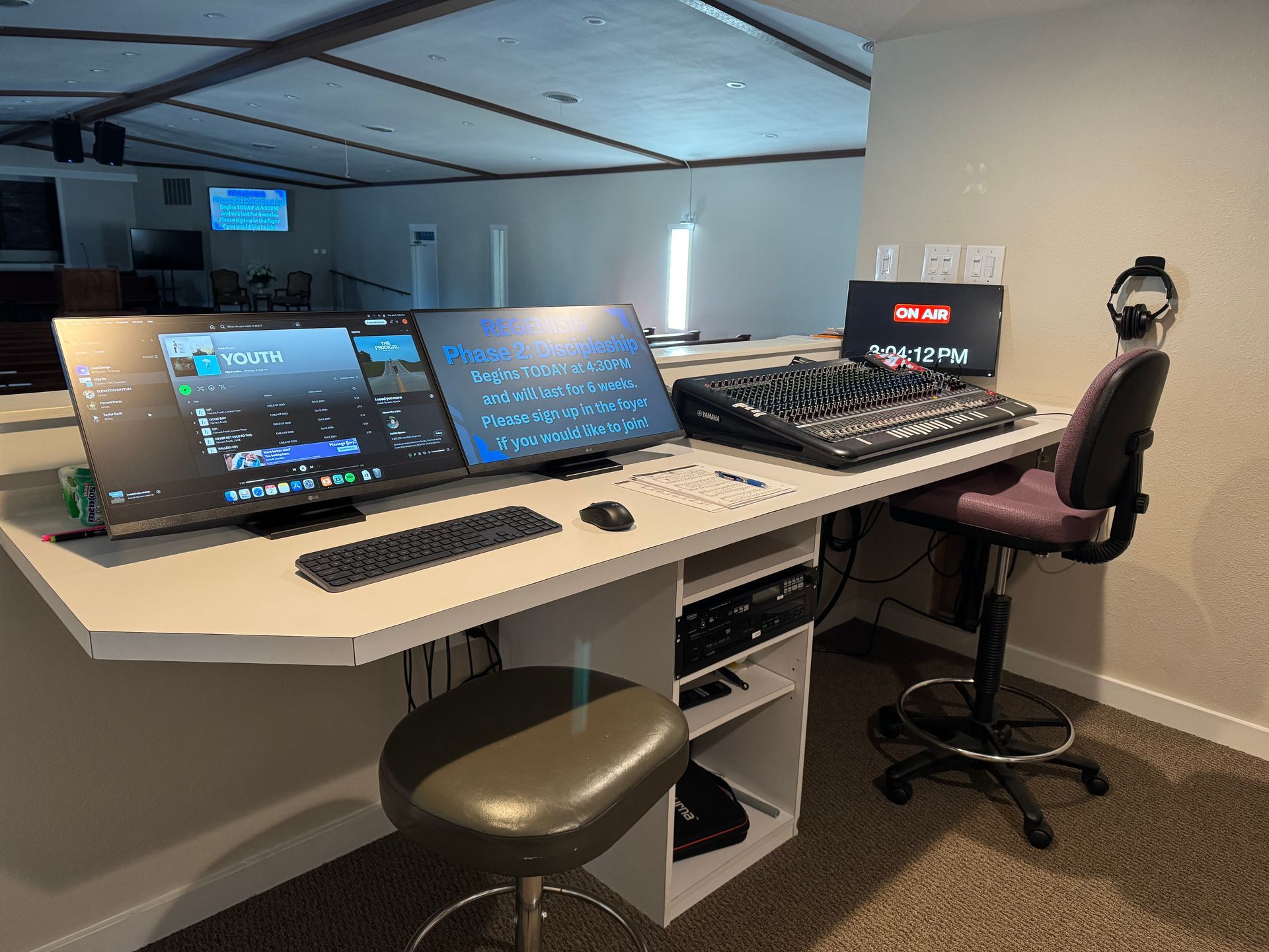 A computer desk with two monitors , a keyboard , and a chair.