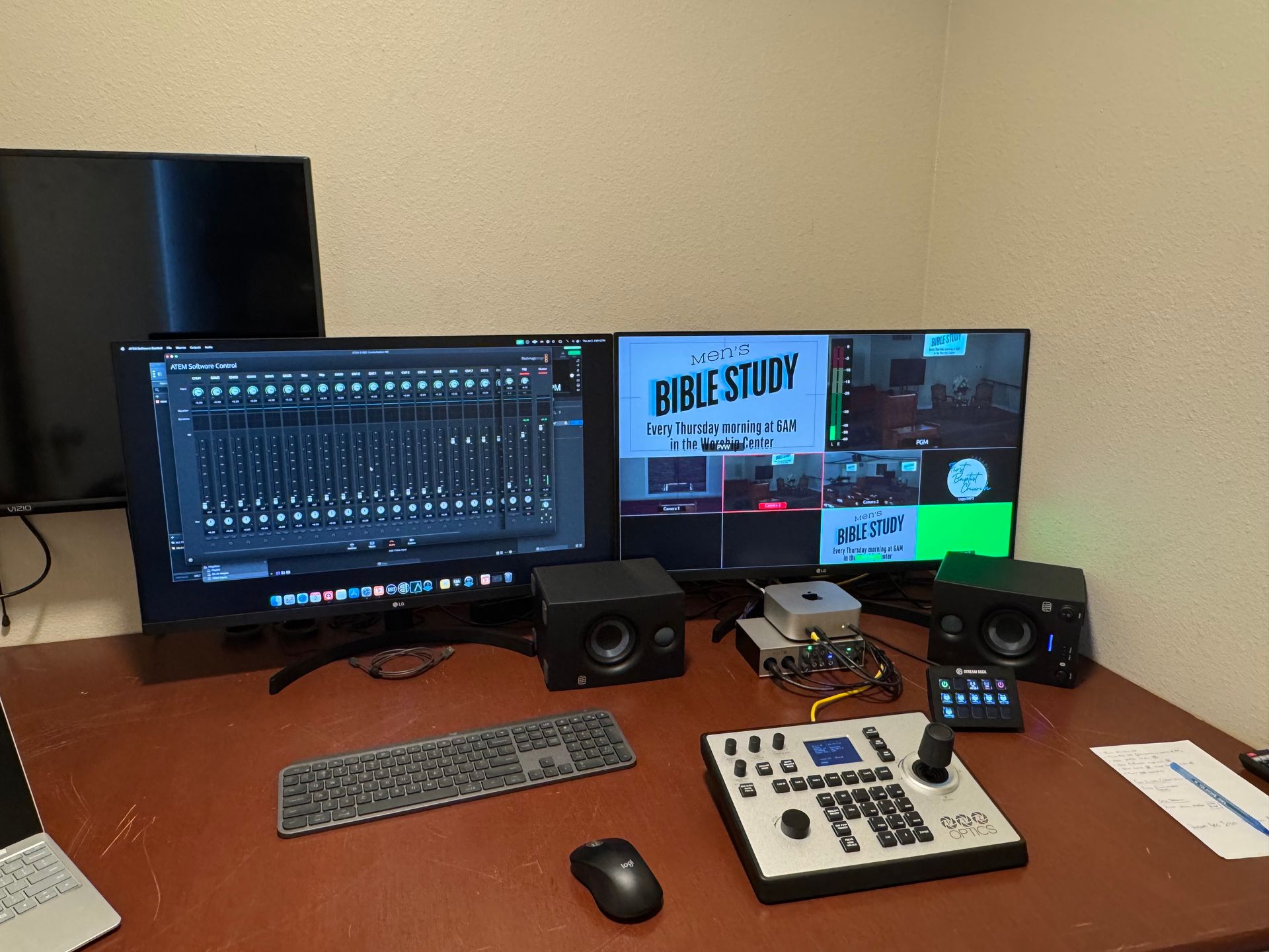 A desk with two monitors , a keyboard , a mouse , and a bible study program on the screen.