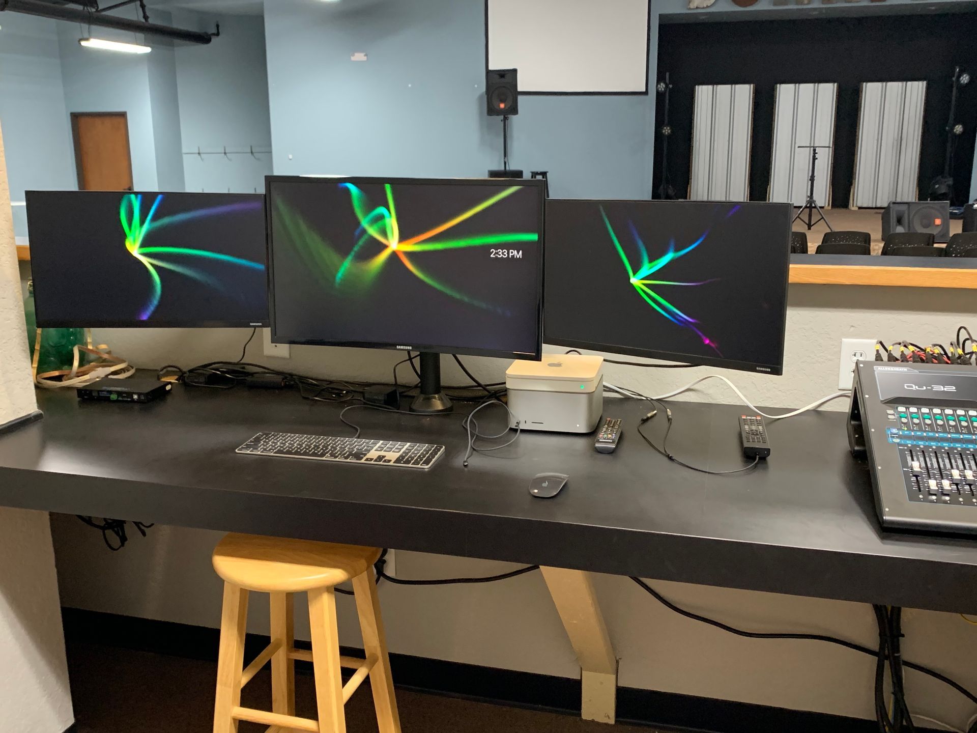 A desk with three monitors and a keyboard on it