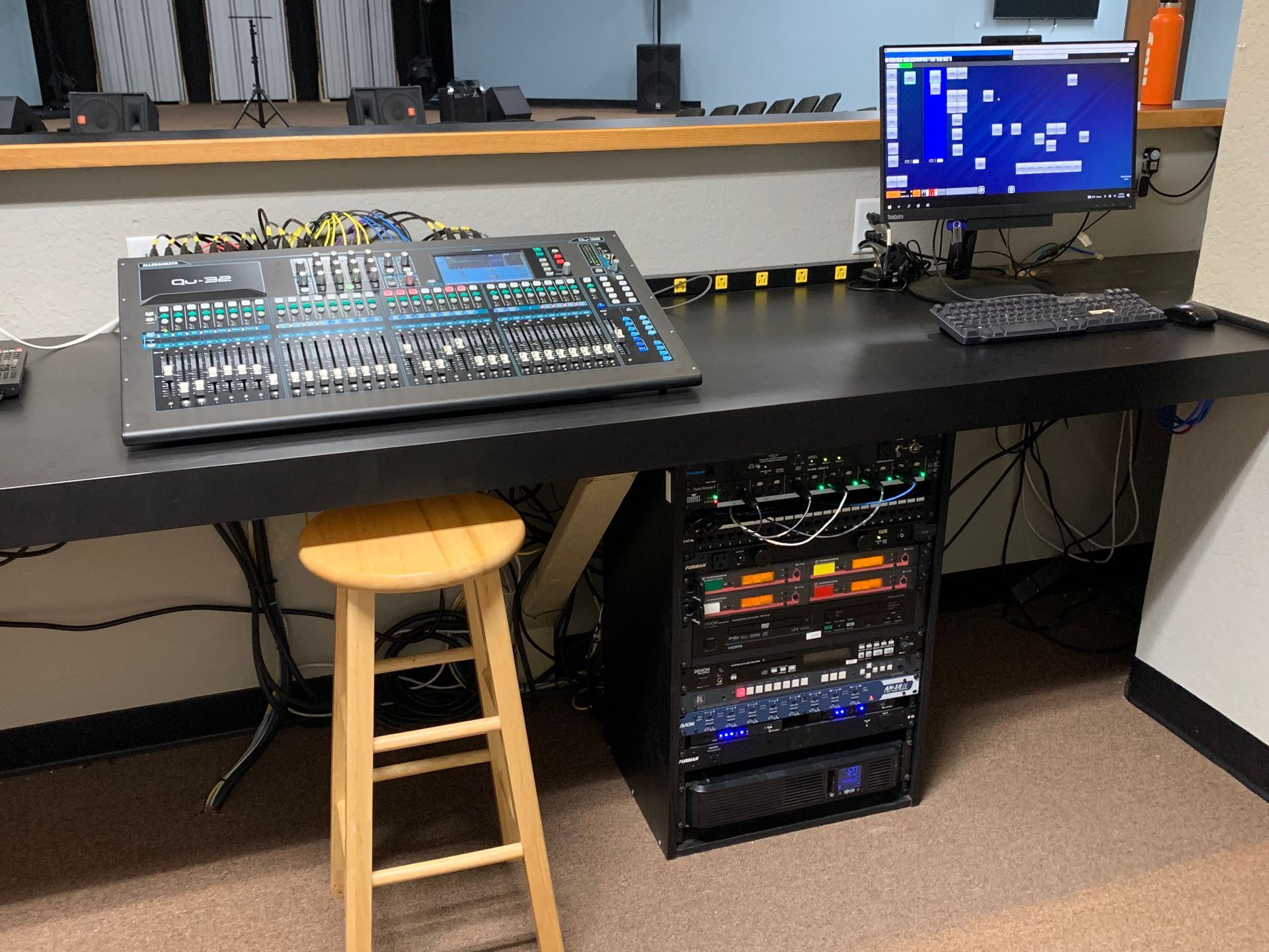 A desk with a computer and a mixer on it.