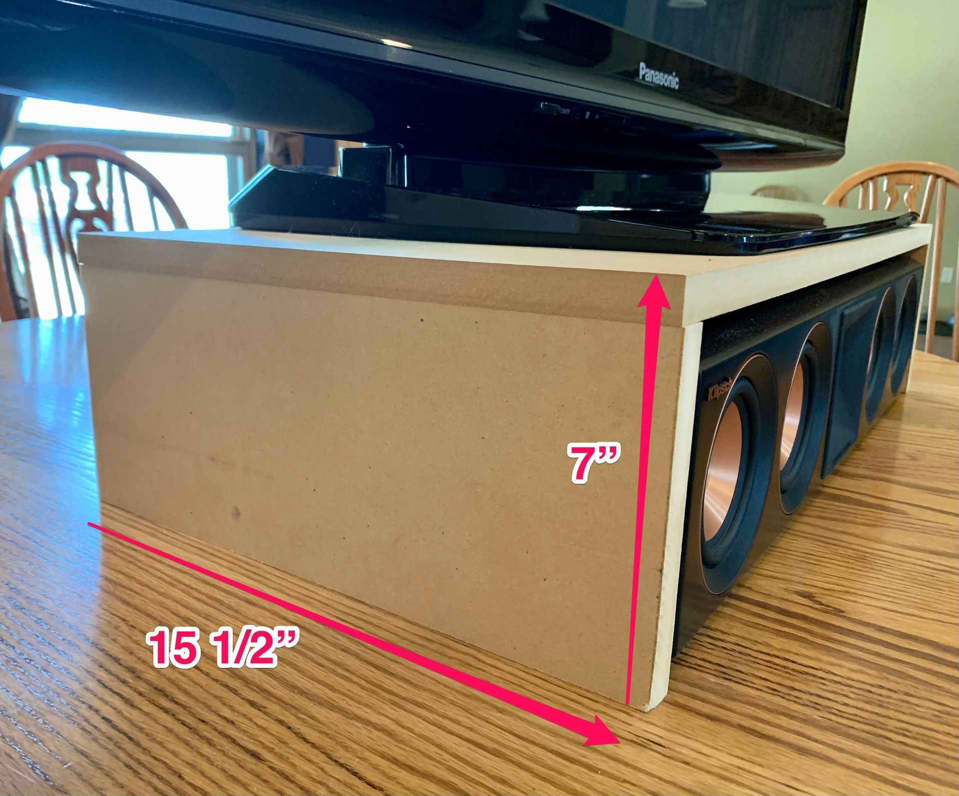 A tv sitting on top of a wooden table next to a box that says 15 1/2 