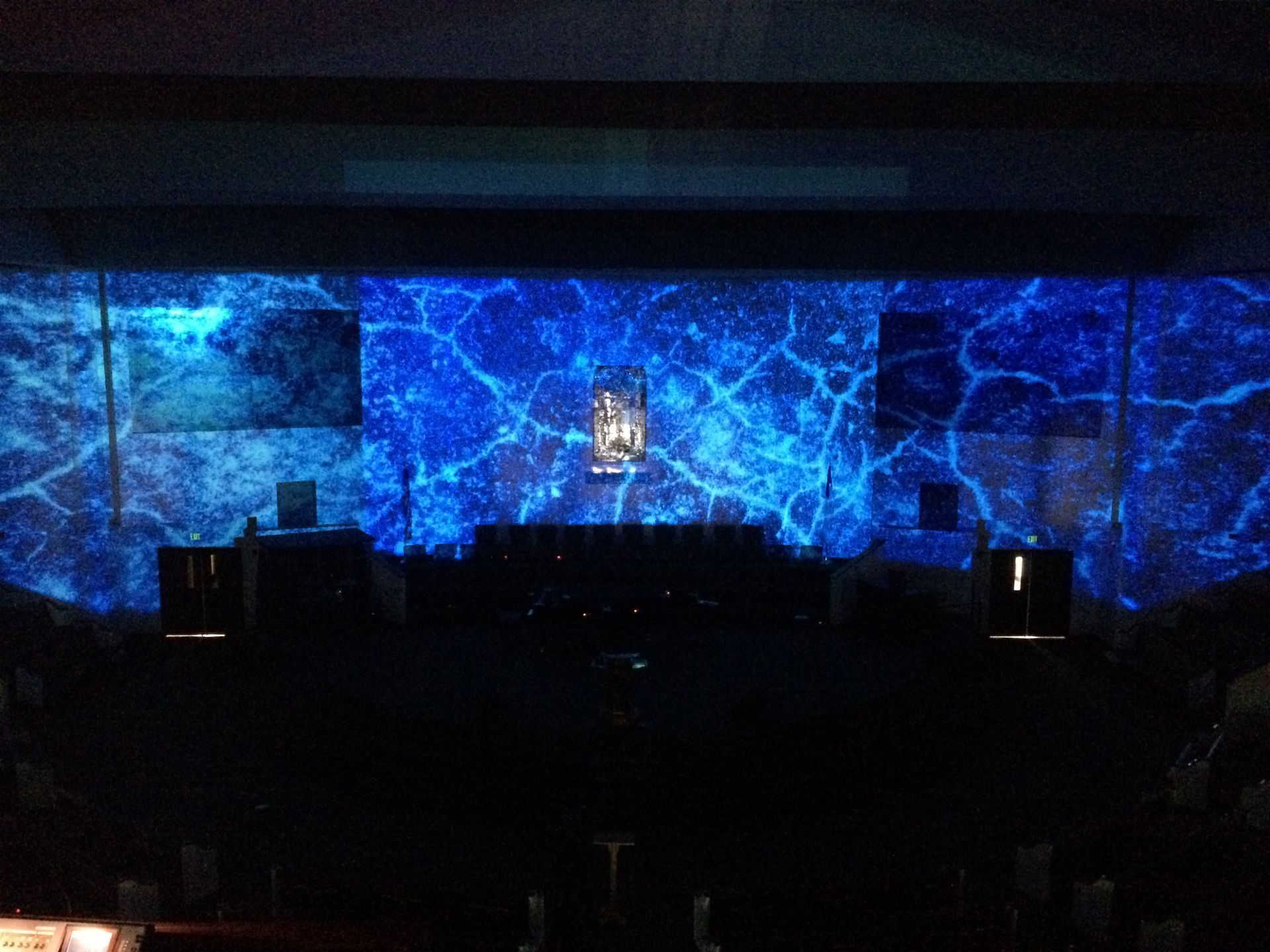 A dark room with blue lights projected on the wall