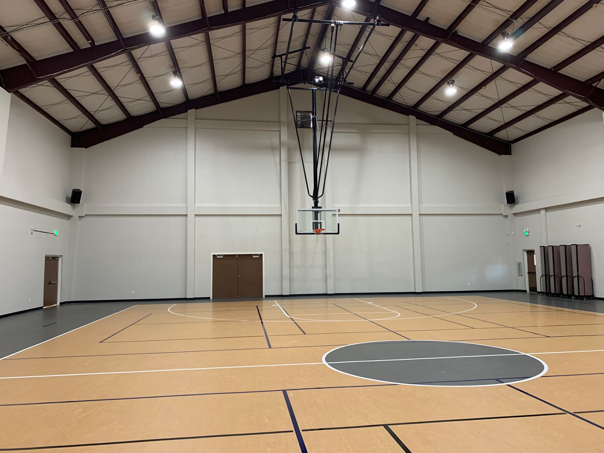 There is a basketball hoop in the middle of the gym.