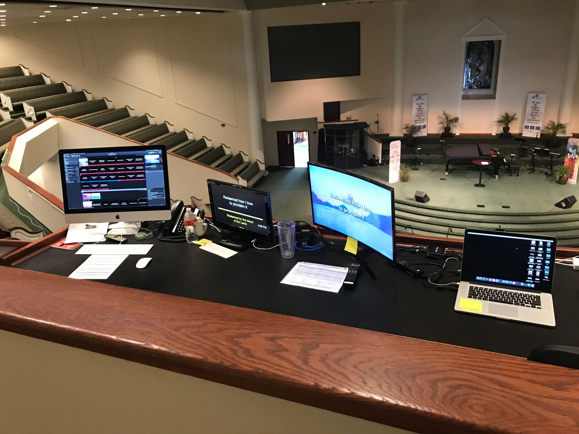 A desk with two computer monitors and a laptop on it